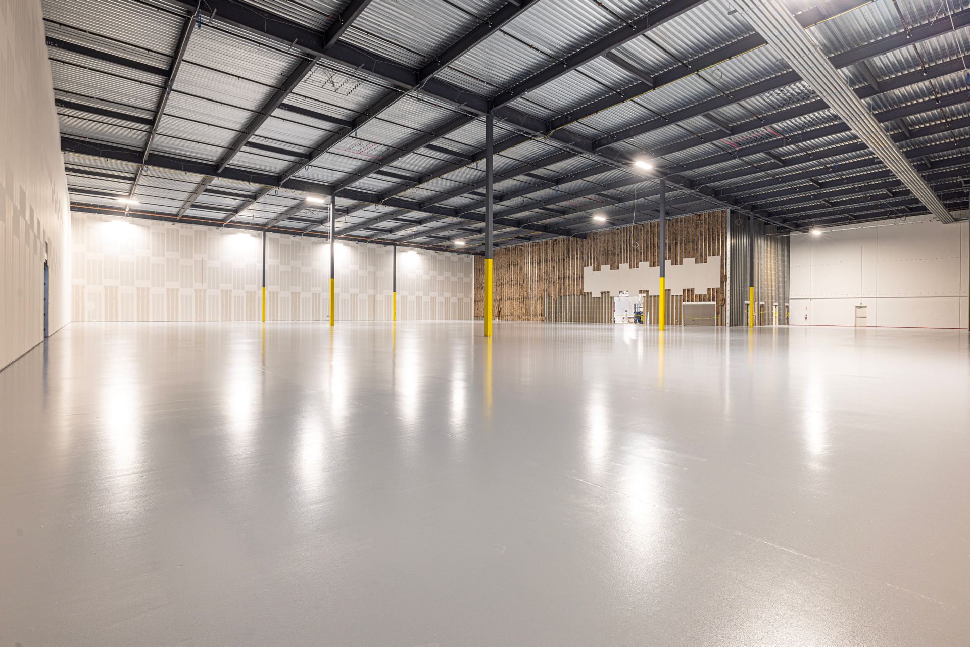 Interior luminos al unei hale industriale mari cu structură metalică